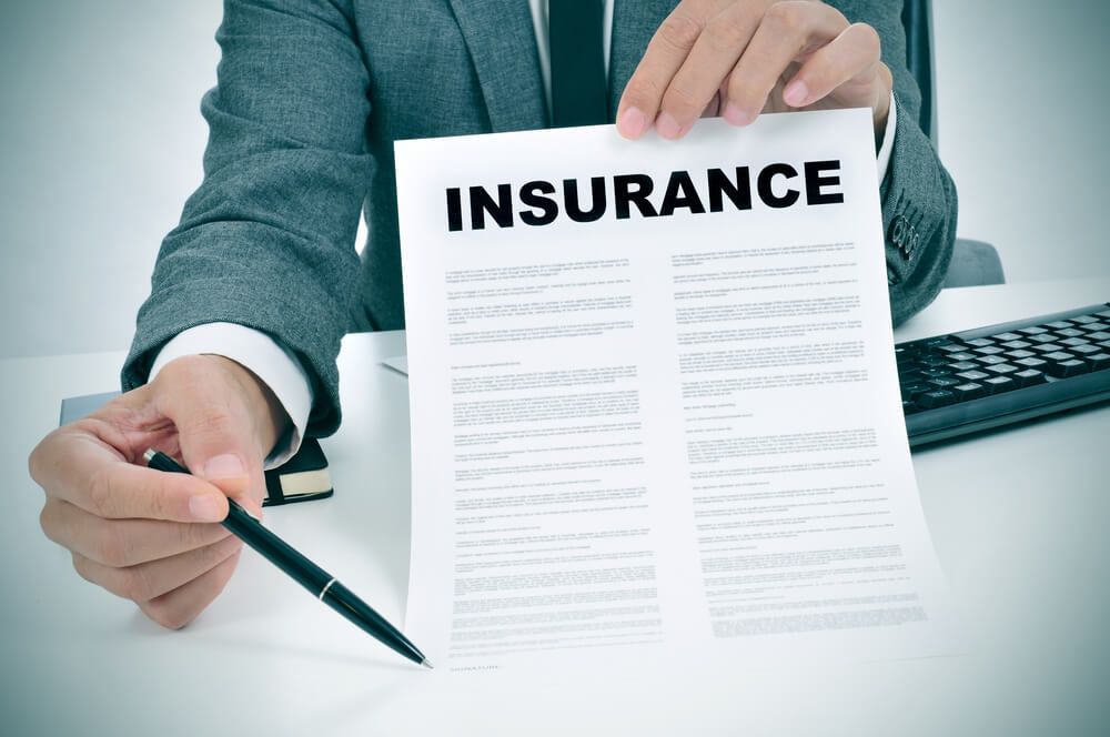 businessman holding insurance papers and pen in his hands